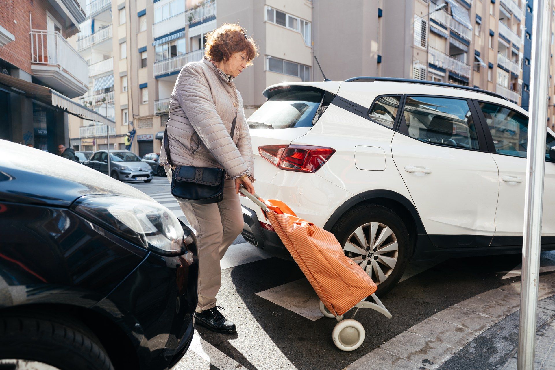 Persona creuant amb un vehicle mal aparcat 