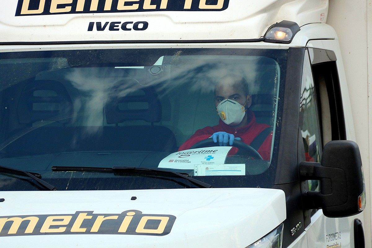 El conductor d'un camió amb mascareta.